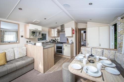 a living room with a couch and a table in a caravan at Combe Martin Beach Holiday Park in Combe Martin