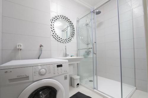 a white bathroom with a washing machine and a shower at Old Town Premium Apartment in Sarajevo