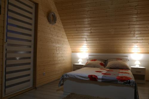 レスコにあるDomki pod Polanąのベッドルーム1室(ベッド1台、ランプ2つ、テーブル2台付)