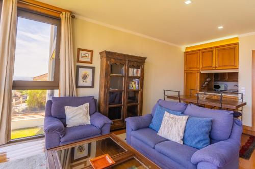 ein Wohnzimmer mit 2 blauen Stühlen und einem Glastisch in der Unterkunft FLH Funchal Amazing Sea View Apartment with Pool in Funchal