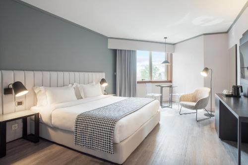 a hotel room with a bed and a desk at HF Fénix Porto in Porto