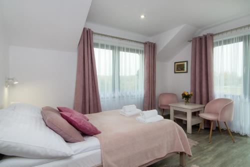 a bedroom with a bed with pink pillows at Za Gościńcem in Kazimierz Dolny