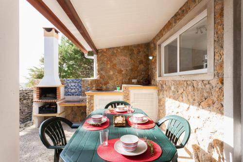 a green table and chairs in a kitchen at FLH Garden Houses near Ericeira in Sintra