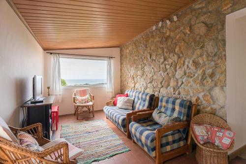 a living room with a couch and a stone wall at FLH Garden Houses near Ericeira in Sintra