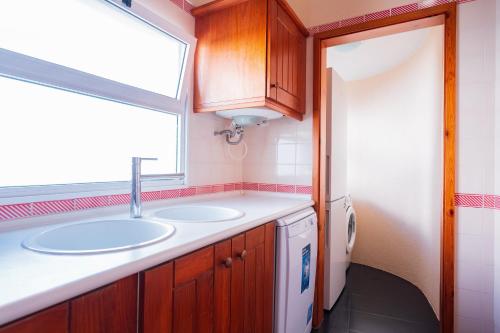 a bathroom with two sinks and a window in it at FLH Funchal Ocean View with Pool in Funchal