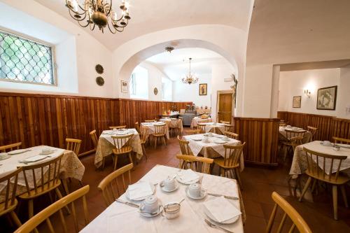 a restaurant with tables and chairs and a chandelier at Gästehaus Deutscher Orden in Rome