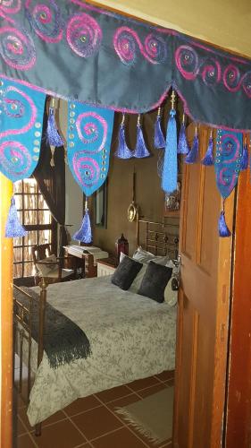 ein Schlafzimmer mit einem Bett mit blauen und violetten Dekorationen in der Unterkunft Wooden Creek Estate in Kempton Park