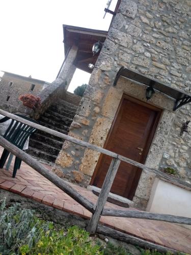 a stone building with a wooden door and stairs at B&B La Pietra in Arpino