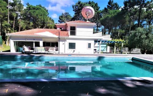 a house with a swimming pool in front of a house at Villa Colares in Sintra