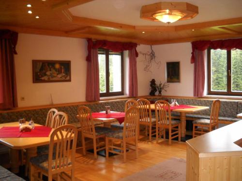 a dining room with tables and chairs and windows at Bauernhof Marx in Gaal