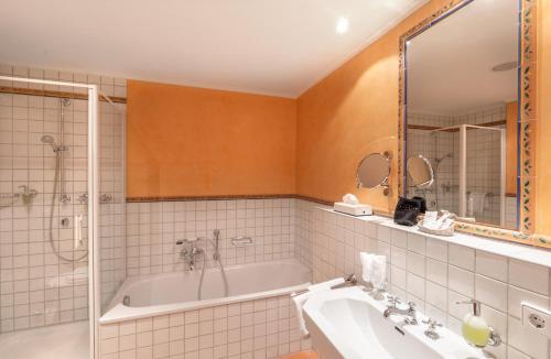 a bathroom with a tub and a sink at Romantik Hotel Residenz am See in Meersburg