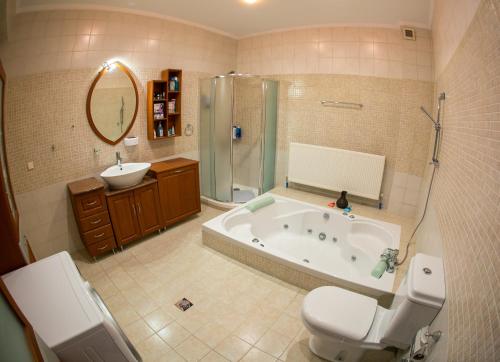 a bathroom with a tub and a toilet and a sink at Vier Luxury House in Serres