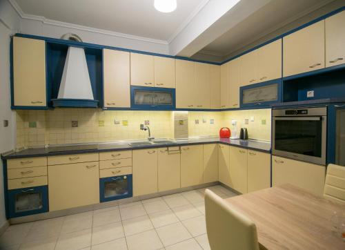 a kitchen with white cabinets and a wooden table at Vier Luxury House in Serres