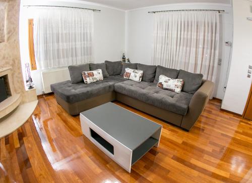 a living room with a gray couch and a table at Vier Luxury House in Serres