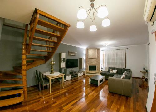 a living room with a staircase and a couch and a table at Vier Luxury House in Serres