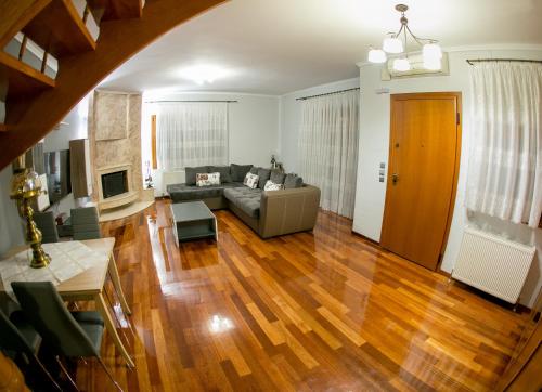 a living room with a couch and wooden floors at Vier Luxury House in Serres