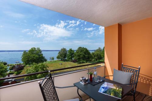a balcony with a table and chairs and a view of the water at Romantik Hotel Residenz am See in Meersburg
