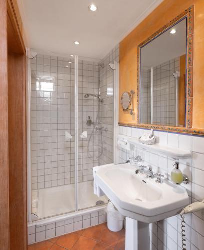 a bathroom with a sink and a shower at Romantik Hotel Residenz am See in Meersburg