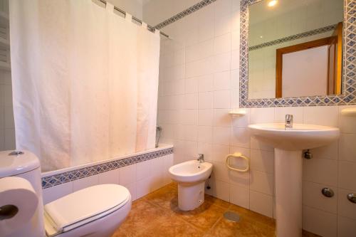 a bathroom with a toilet and a sink and a mirror at Chalet Pedro III in Conil de la Frontera