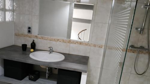La salle de bains est pourvue d'un lavabo et d'une douche. dans l'établissement Duplex au Coeur de Lunel, à Lunel