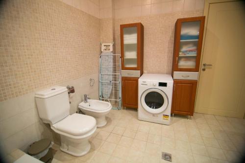 a bathroom with a toilet and a washing machine at Vier Luxury House in Serres