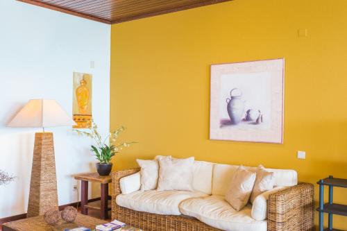 a living room with a couch and a yellow wall at FLH Luxury Villa Mar with Private Sea Access in Caniçal