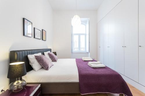 リスボンにあるFLH Graça Spacious Flatのベッドルーム1室(紫の毛布が敷かれたベッド1台付)