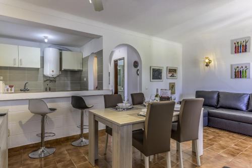 een keuken en woonkamer met een tafel en stoelen bij FLH Gaivotas Cozy House in Porches