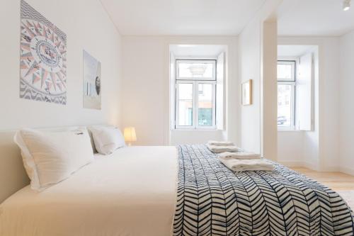 リスボンにあるFLH Intendente Modern Terraceの白いベッドルーム(大型ベッド、タオル付)