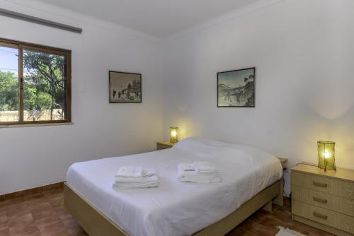 een slaapkamer met een wit bed met handdoeken erop bij FLH Gaivotas Cozy House in Porches