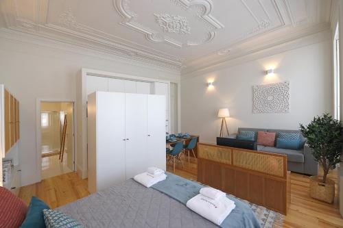 a bedroom with a bed and a living room at FLH Living Oporto Lofts in Porto