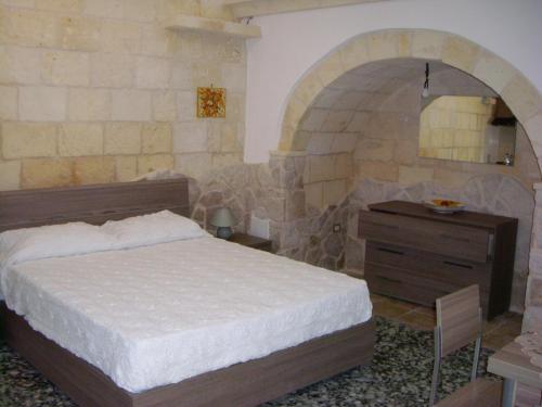 een slaapkamer met een bed en een houten dressoir bij La Casetta in Oria