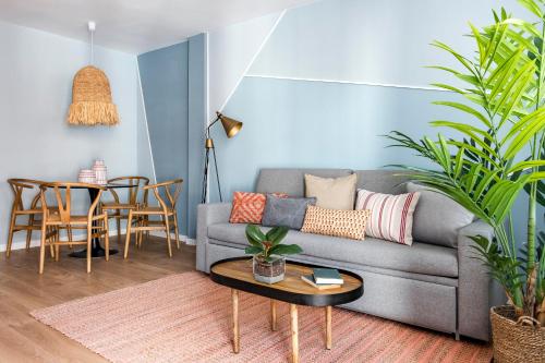 een woonkamer met een grijze bank en een tafel bij Color Apartments by Olala Homes in Madrid
