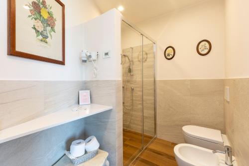 e bagno con doccia, servizi igienici e lavandino. di Villa Rubino Apartment con giardino e jacuzzi vista lago a Stresa