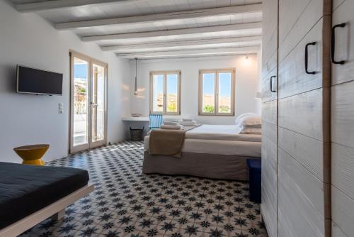a hotel room with two beds and a tv at Milia Gi Suites in Pollonia