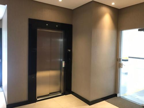 a elevator room with a door and a window at Apartamento 2 dormitórios a 350 metros do mar na Meia Praia - Itapema-sc in Itapema