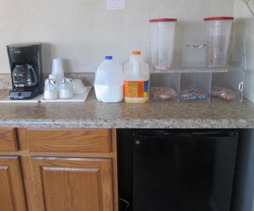 a kitchen counter with bottles of milk and coffee at Budgetel Inn & Suites in Rockingham