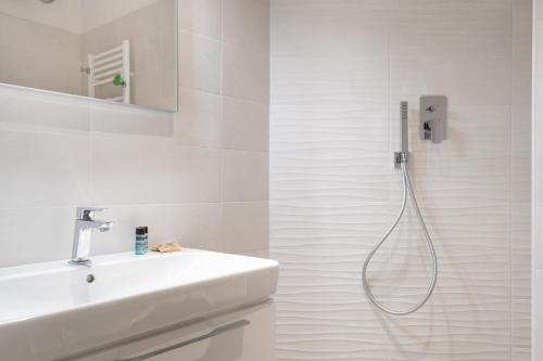 uma casa de banho branca com um lavatório e um chuveiro em Residence delle Erbe by Studio Vita em Bolonha
