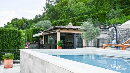 a swimming pool in front of a house at Apartments Vunić in Mošćenička Draga