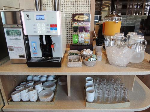 a counter with a coffee maker and other kitchen items at Hotel Coco Grand in Takasaki