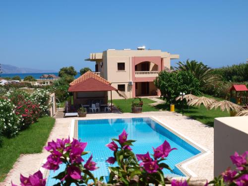 une villa avec une piscine en face d'une maison dans l'établissement Villa Rita Apartments A, à Tavronítis