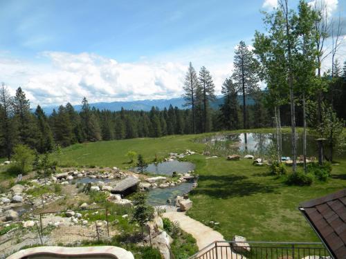 a river in a field with rocks and trees at Talus Rock Retreat in Sandpoint