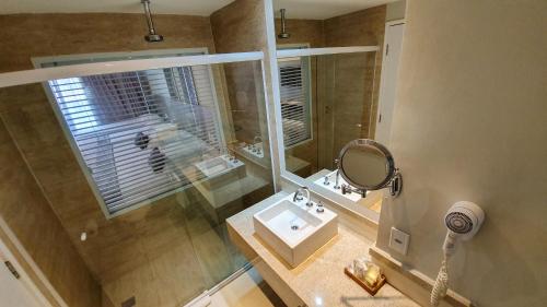 a bathroom with a shower and a sink and a mirror at Blue Tree Premium São Luis in São Luís