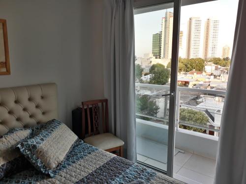 um quarto com uma cama e vista para a cidade em CALIDO-Departamento 1 dormitorio amueblado excelente ubicacion em Río Cuarto