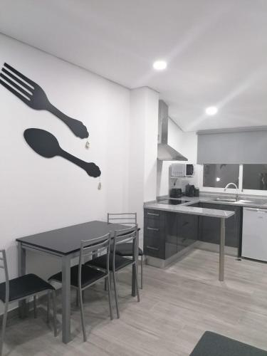 a kitchen with a table and a fork on the wall at Casinhas do Canário in Montoito