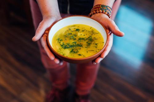 a person is holding a bowl of soup at Ecolodge La Estancia in Comunidad Yumani