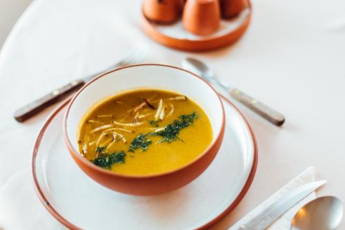 a bowl of soup on a plate on a table at Ecolodge La Estancia in Comunidad Yumani