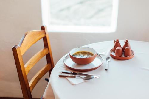 a table with a bowl of soup and a bowl of shoes at Ecolodge La Estancia in Comunidad Yumani