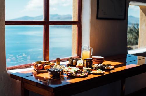 a table with food on it in front of a window at Ecolodge La Estancia in Comunidad Yumani
