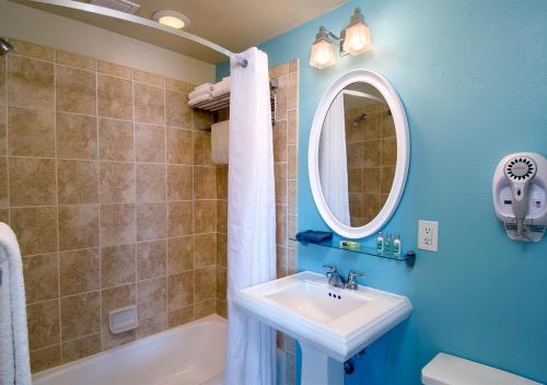 a blue bathroom with a sink and a mirror at Palm Pavilion Inn in Clearwater Beach
